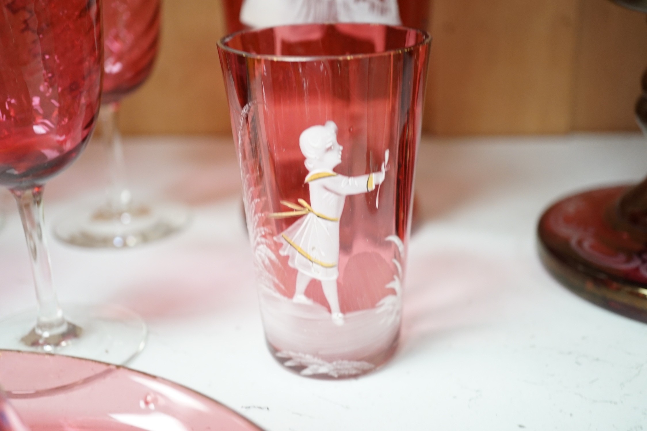 A collection of cranberry glass, a dump paperweight, another and a sweetmeat jar, tallest 28.5 cm
